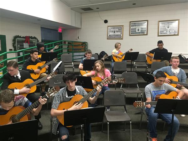 Students are learning how to play guitar 