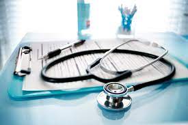 A stethoscope resting on a clipboard on a blue writing surface