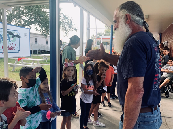 Anona Elementary student salutes a Veteran during the Veterans Day Celebration.