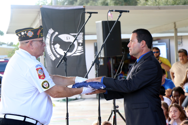 Seminole Elementary Principal Lou Cerreta, receives the flag during the Veterans Day Flag Ceremony.