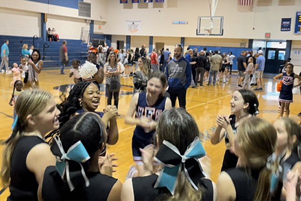 Pinellas County Schools stick together and cheer each other on. Carwise and Morgan Fitzgerald were competing in basketball playoffs but they are a great role model for good sportsmanship as the cheer squads cheered together .